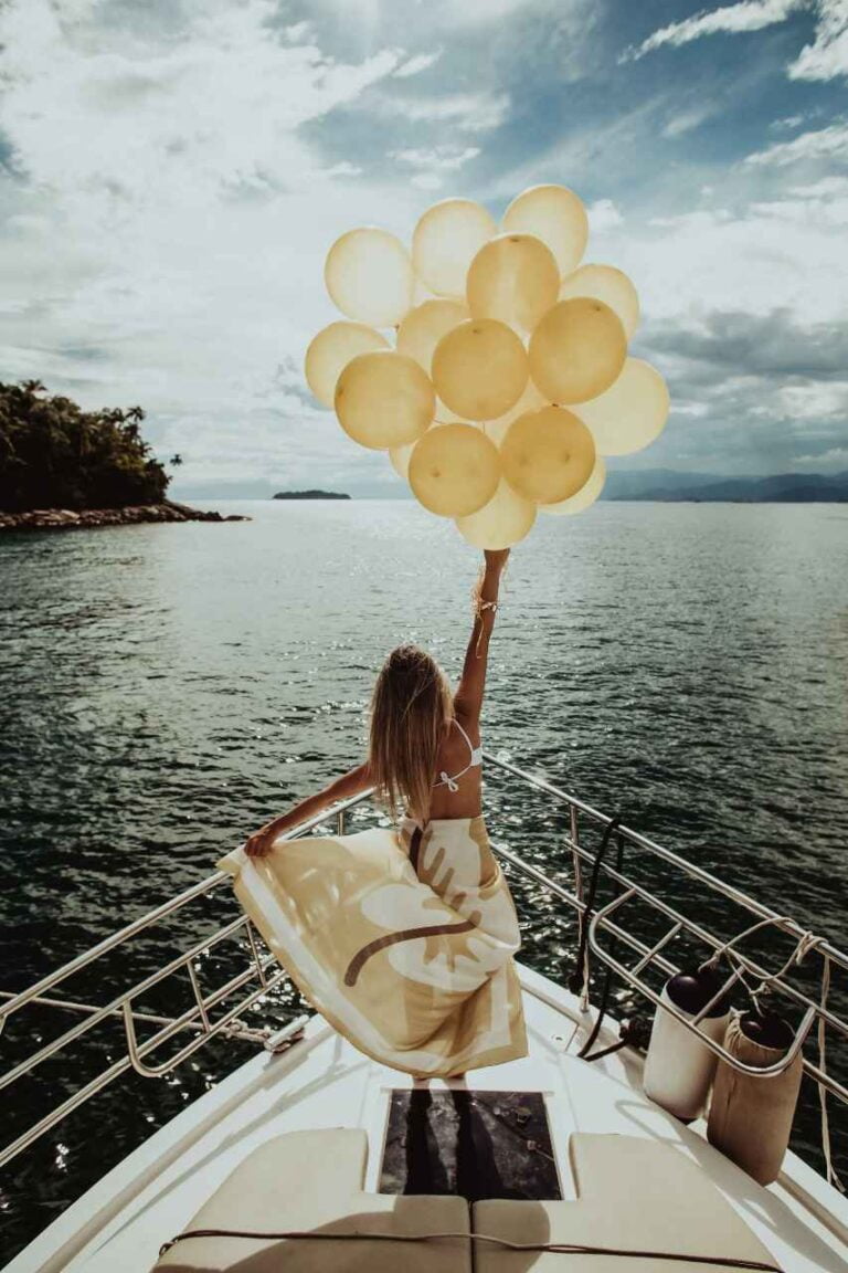 Girl celebrating a birthday, holding balloons on the yacht